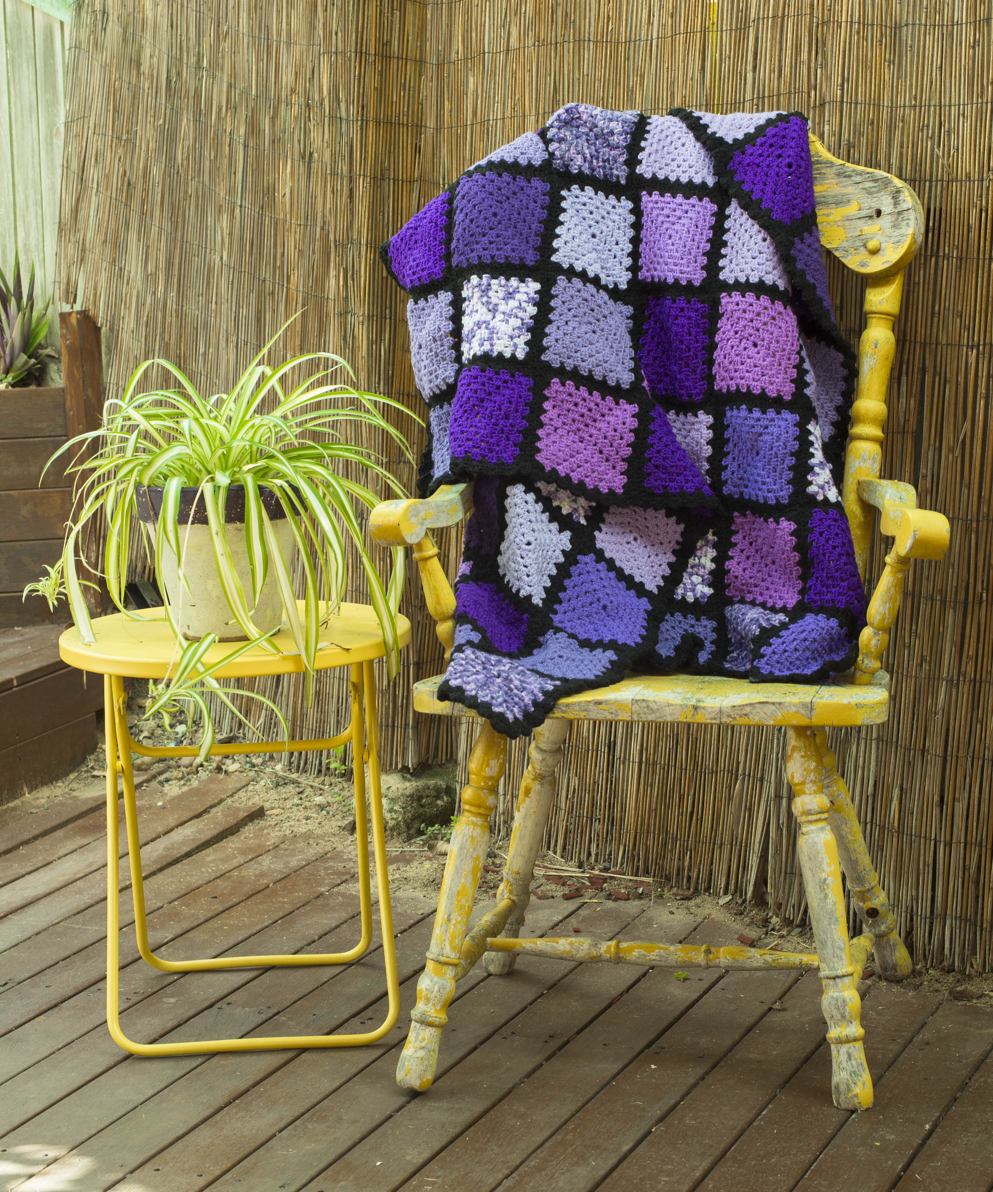 Geometrical Rug, with patchwork squares in shades of purple, lilac and white, with a black trim. Order by name of "Sarah".