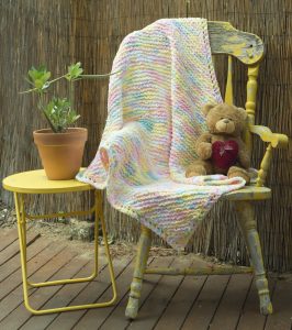 Pastel Striped Baby Blanked with Pinks, Blues, Yellows and Whites interwoven, with a teddy bear. Order by the name of "Joyce".