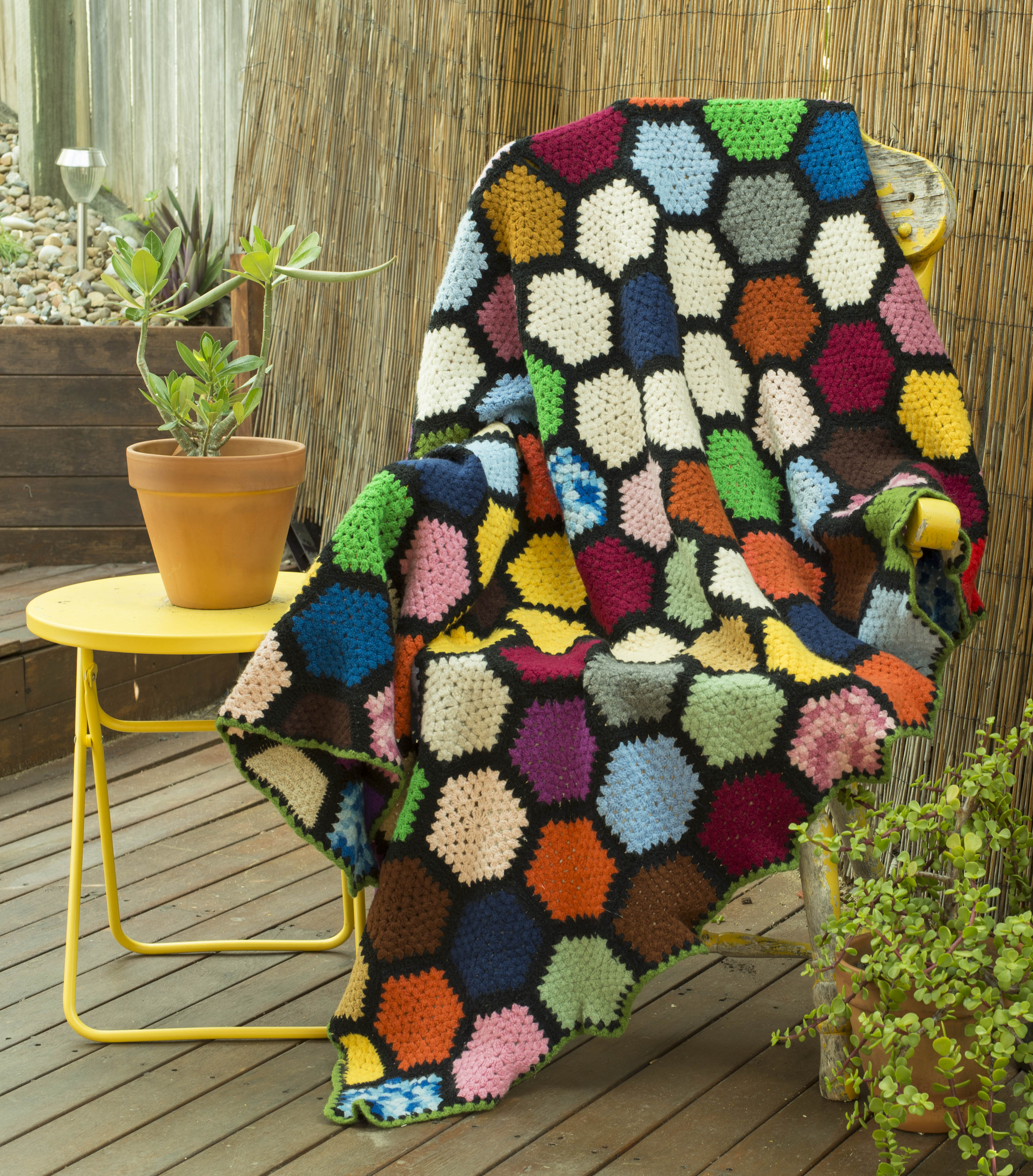 Hexagonal Rainbow Rug with navy, white, pale blue, purple, pink, orange, grey, yellow, brown and green hexagons, with a black trim. Order by name of "Wendy".
