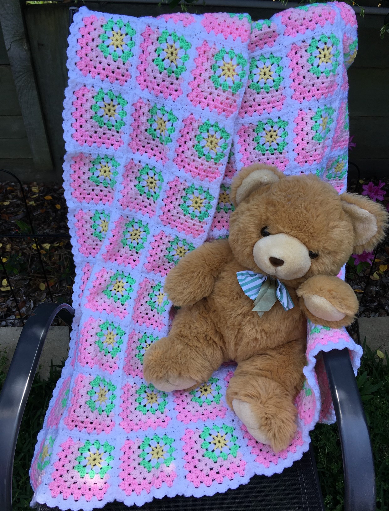Rug with Pastel Pink and White Squares and smaller green squares inside and a yellow sun inside the green square. Designed for a cot.